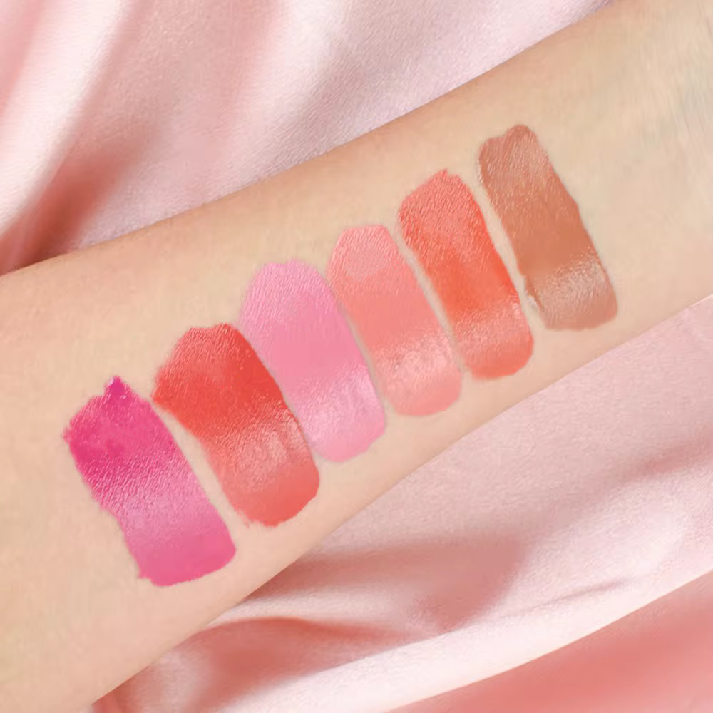 Arm swatches of 6 high-pigment liquid blush shades ranging from nude to berry, showing color payoff for OEM production.